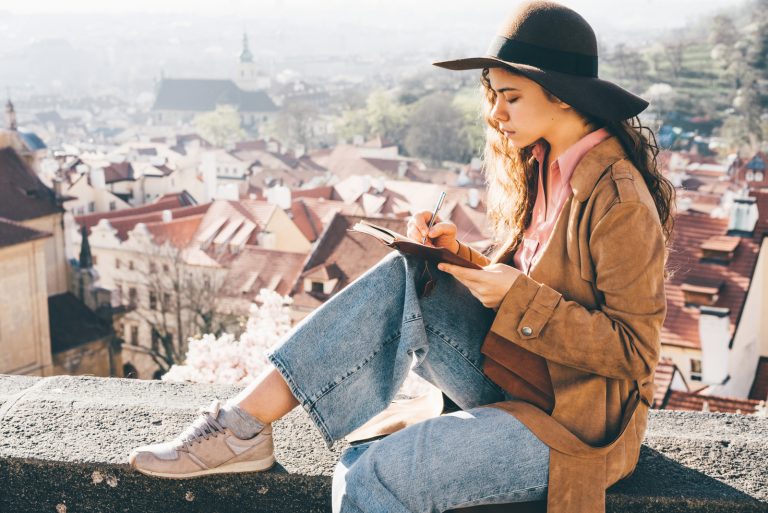 la femme est assise sur le mur et écrit une lettre