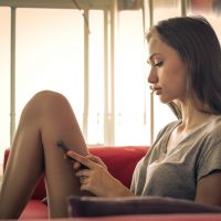 femme assise et bouton sur le téléphone