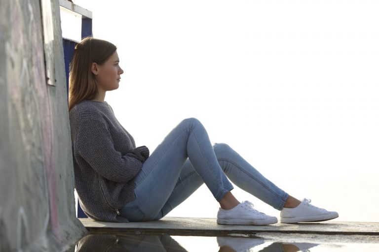 une fille triste assise sur le sol