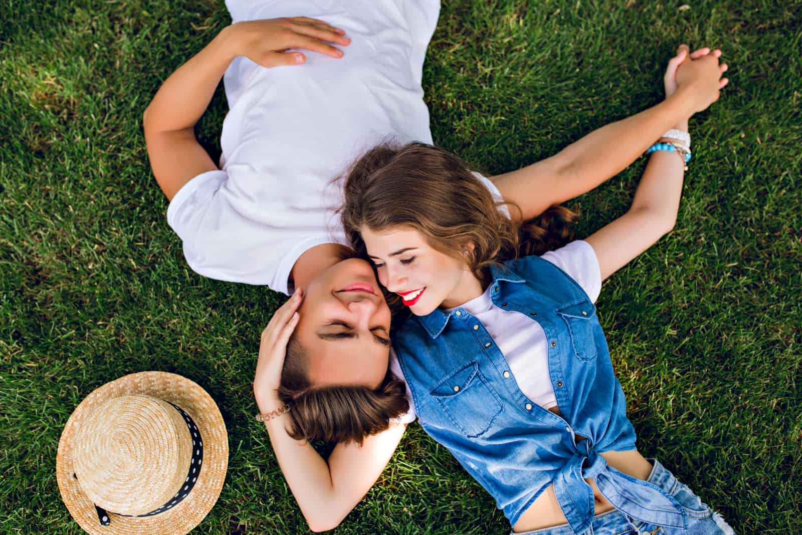 un couple romantique amoureux allongé sur l'herbe et câlins