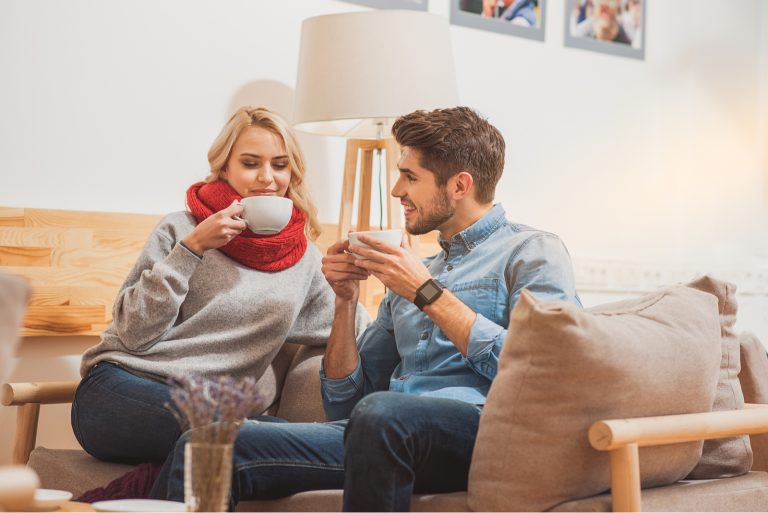 un homme et une femme sont assis en train de boire du café