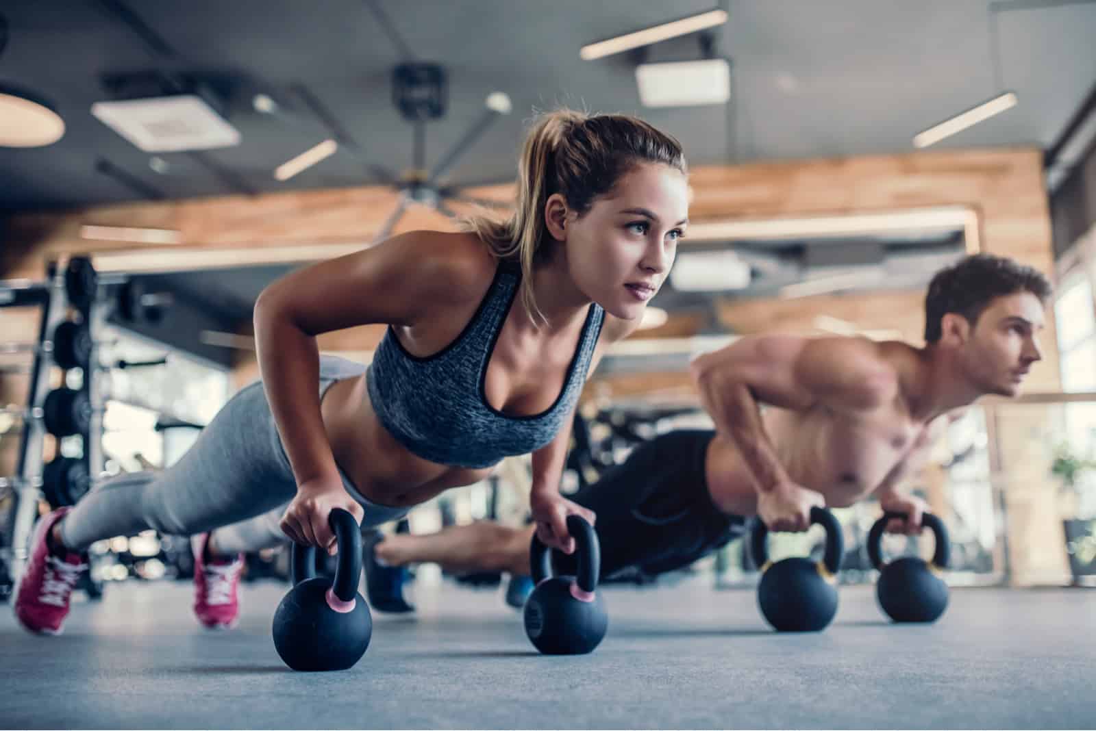un homme et une femme s'entraînent dans la salle de sport