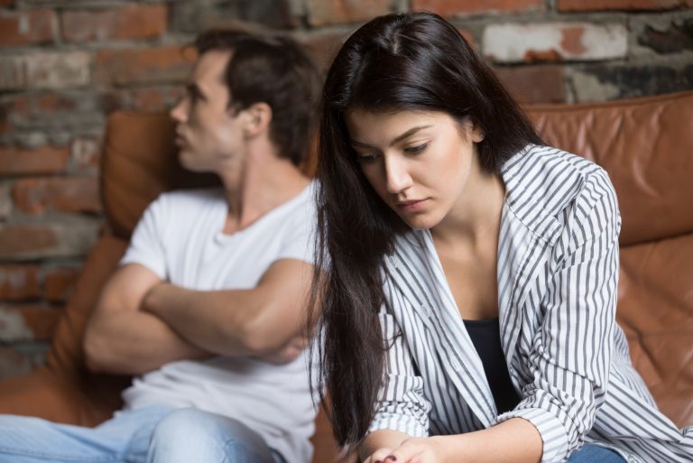 triste couple sérieux assis sur un canapé