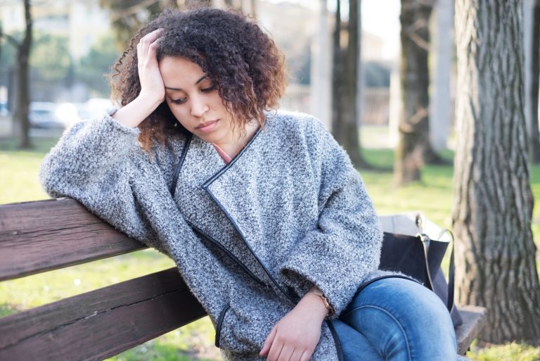 femme triste assise seule sur le banc