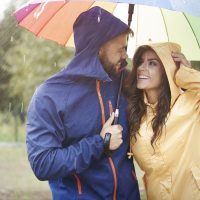 un homme et une femme riant sous des parapluies