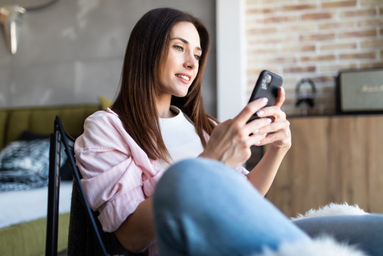 femme assise sur une chaise et un bouton sur le téléphone