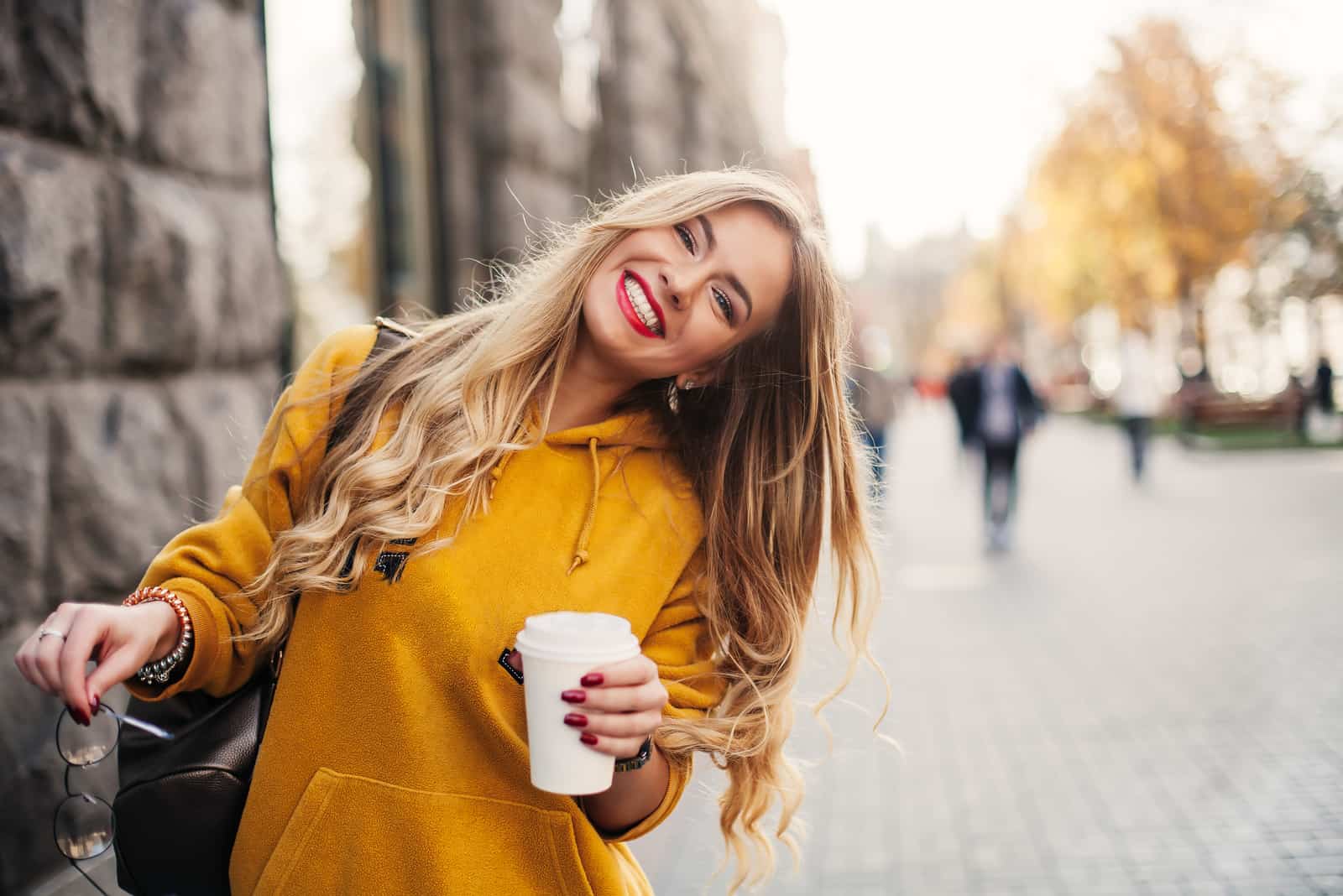 une femme aux longs cheveux blonds se dresse et rit
