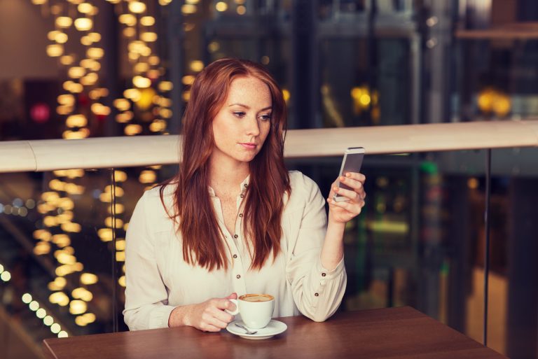 une femme assise avec un téléphone à la main