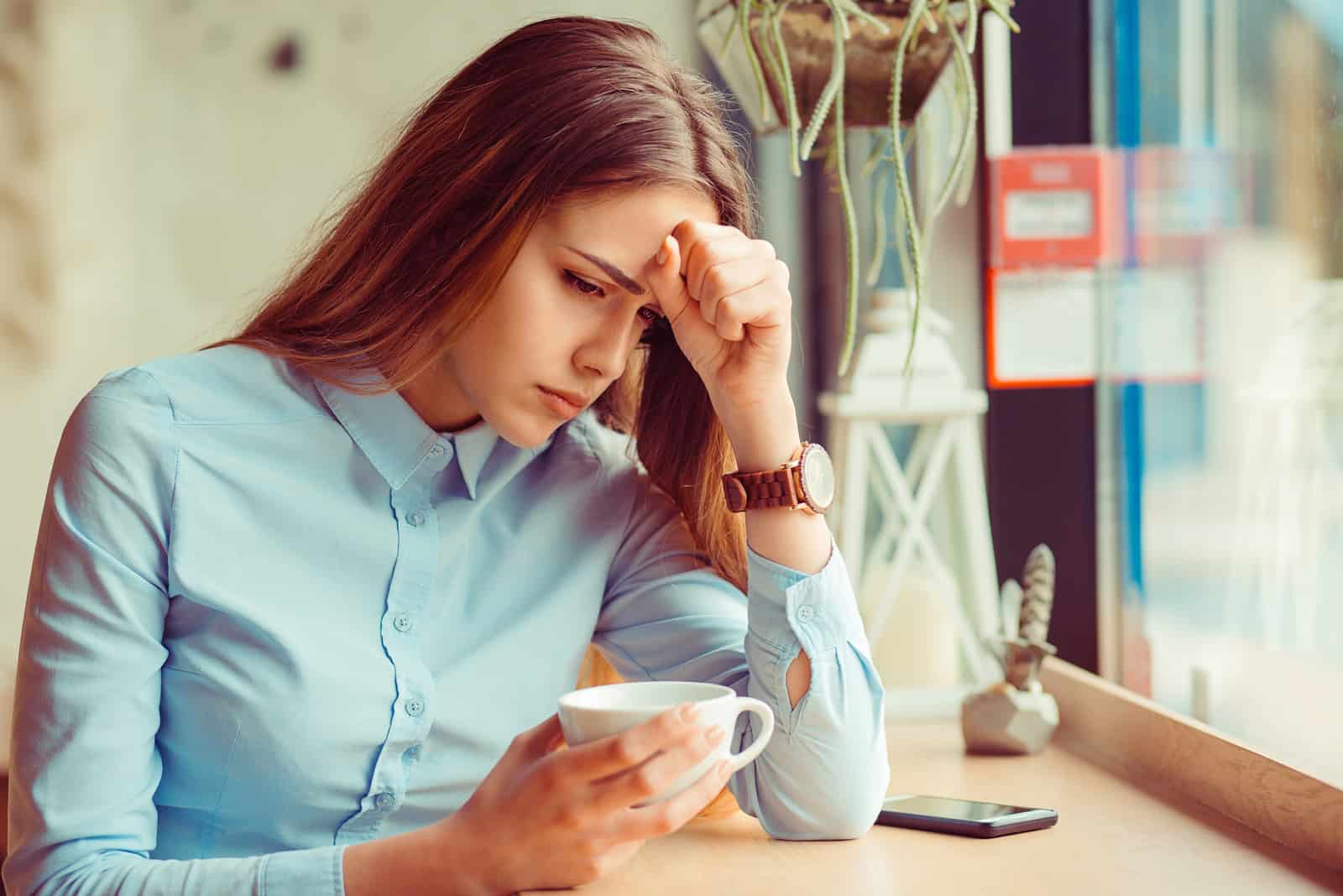 a souligné triste jeune femme avec une tasse de café