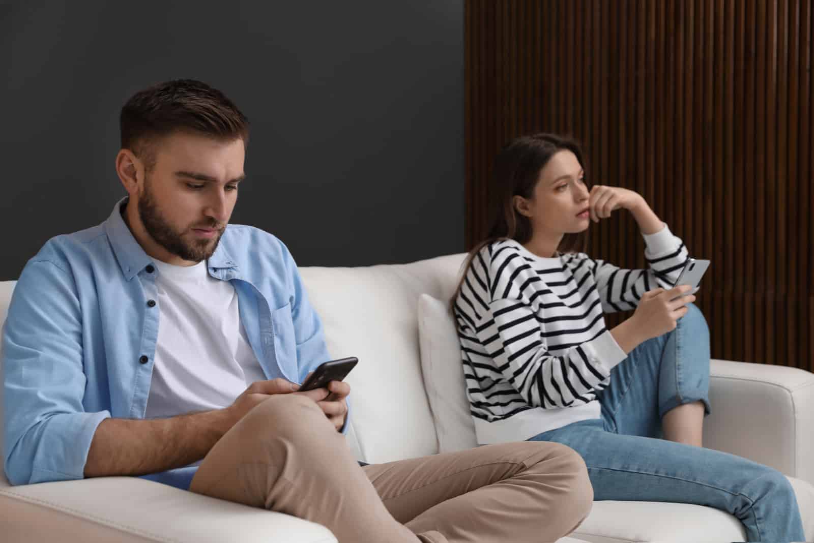 couple tenant des smartphones s'ignorant à la maison