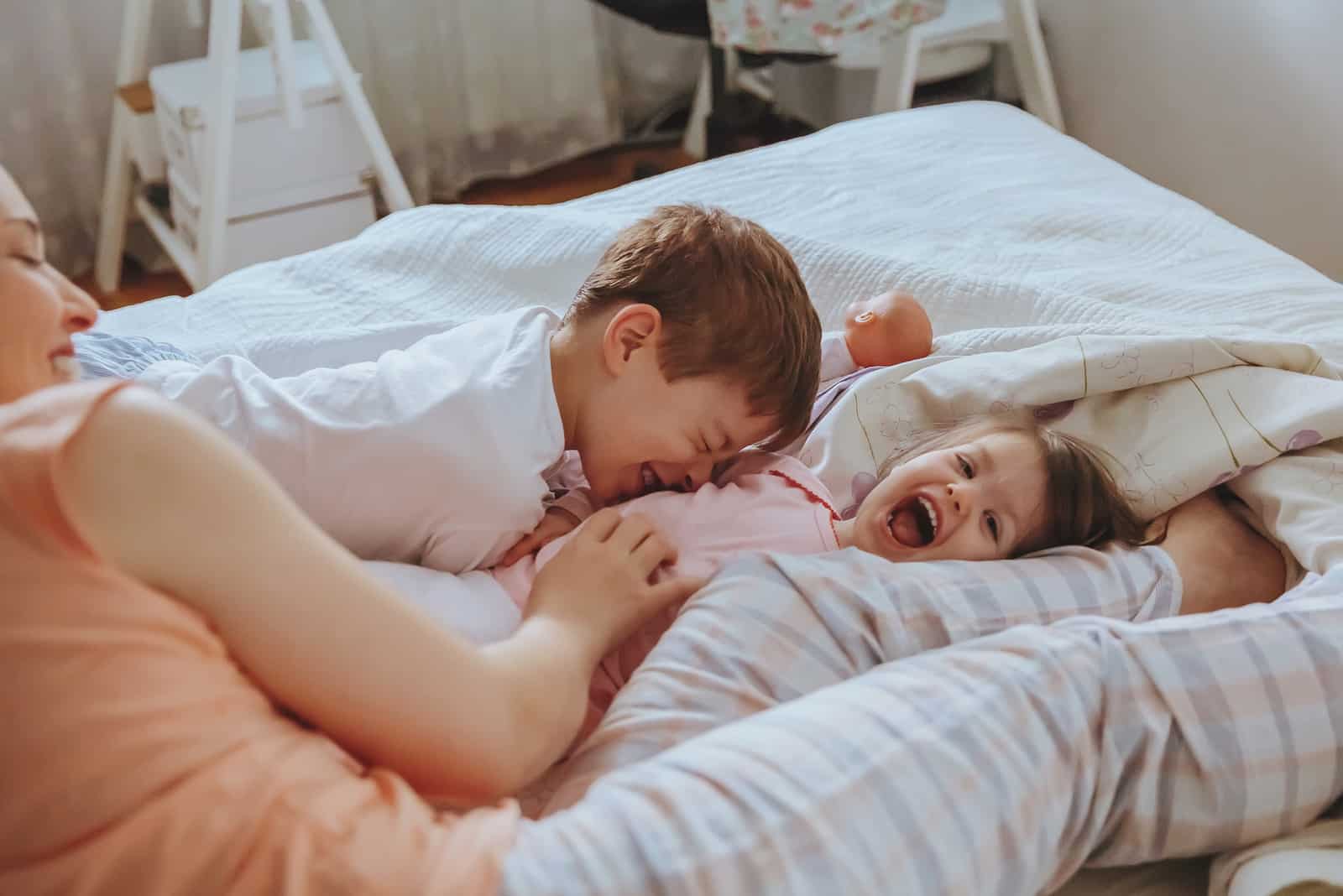famille heureuse jouant sur le lit dans une matinée détendue