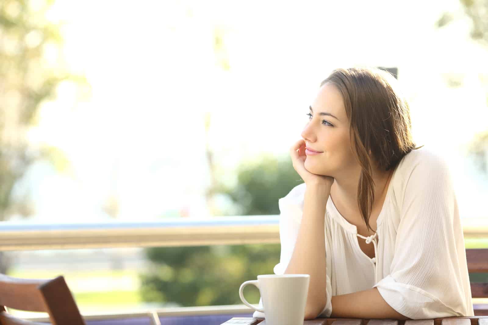 femme heureuse assise dans un bar ou une terrasse à la maison