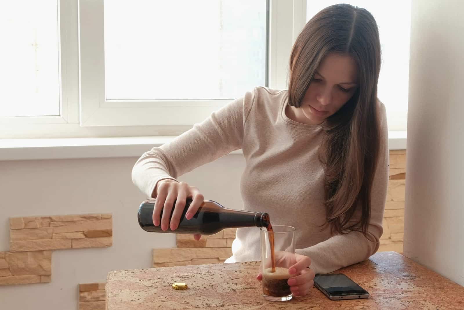 femme verse de la bière dans un verre