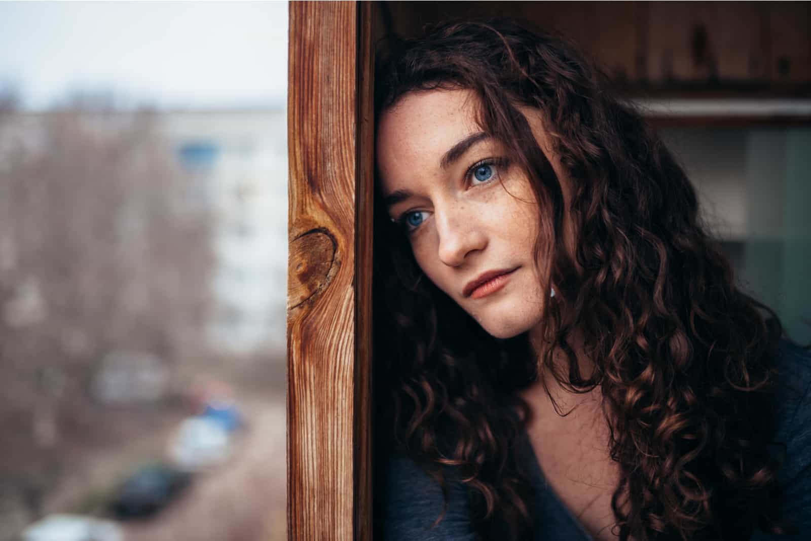 fille solitaire assise près de la fenêtre