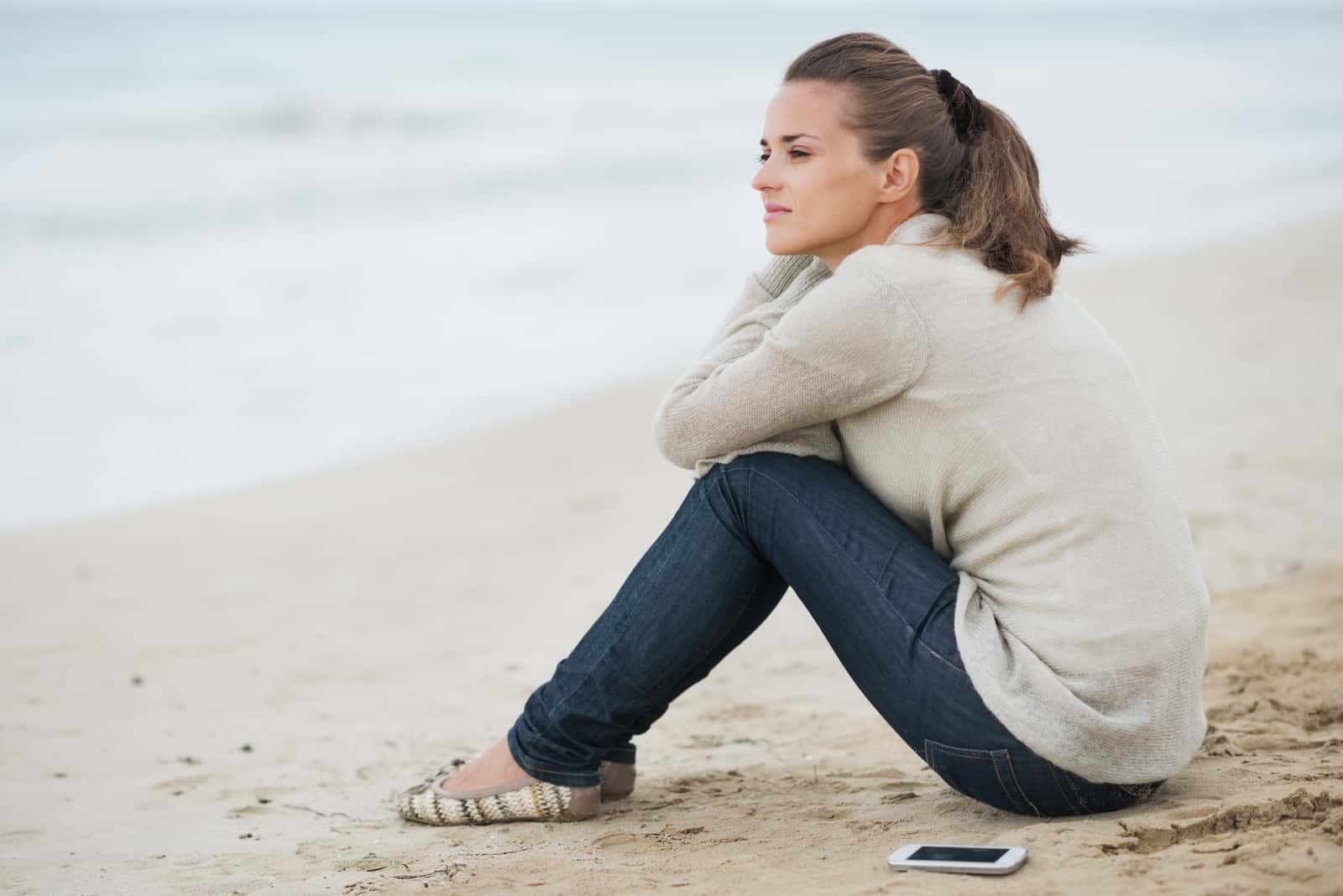 la femme est assise seule sur la plage