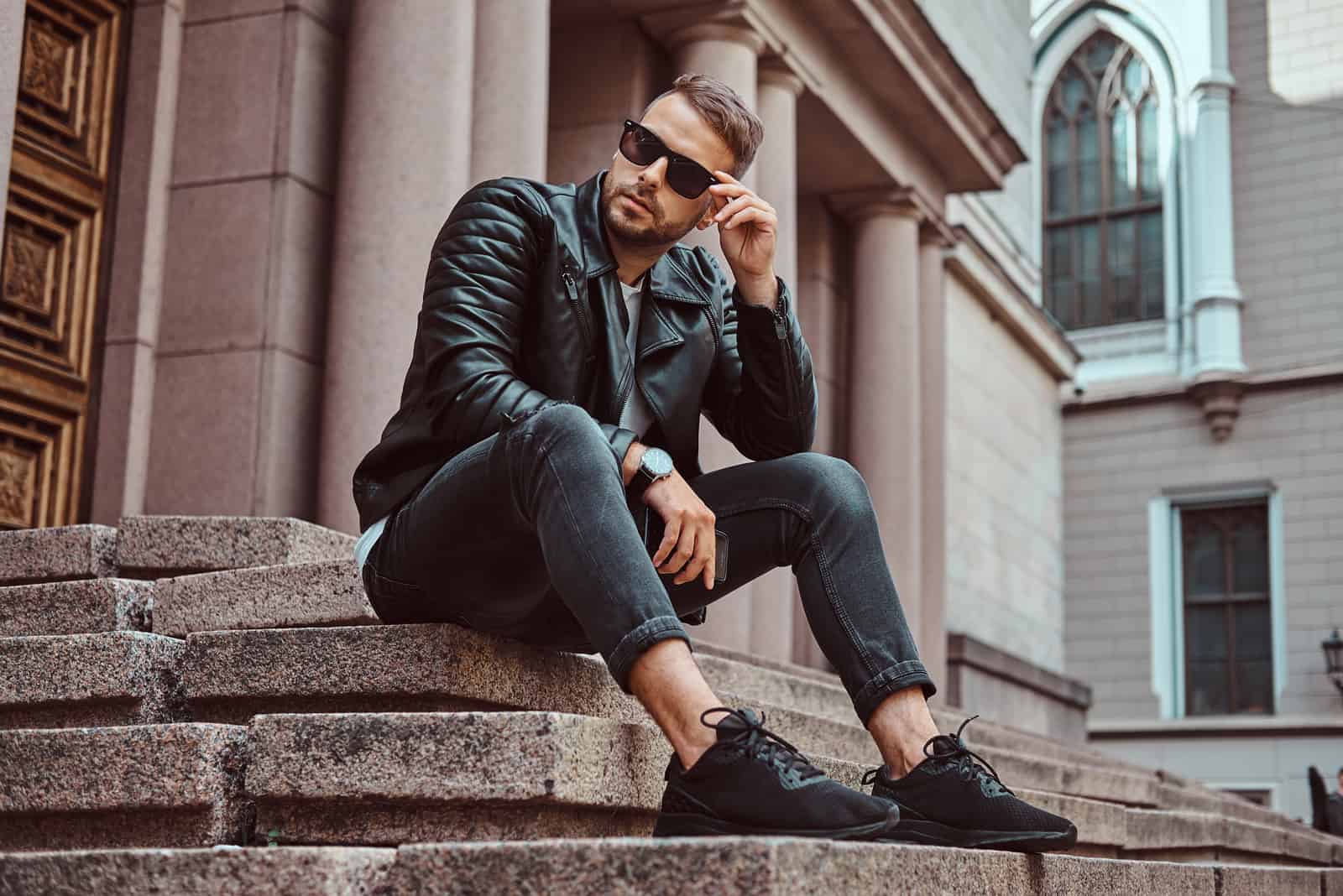 mec vêtu d'une veste noire et d'un jean