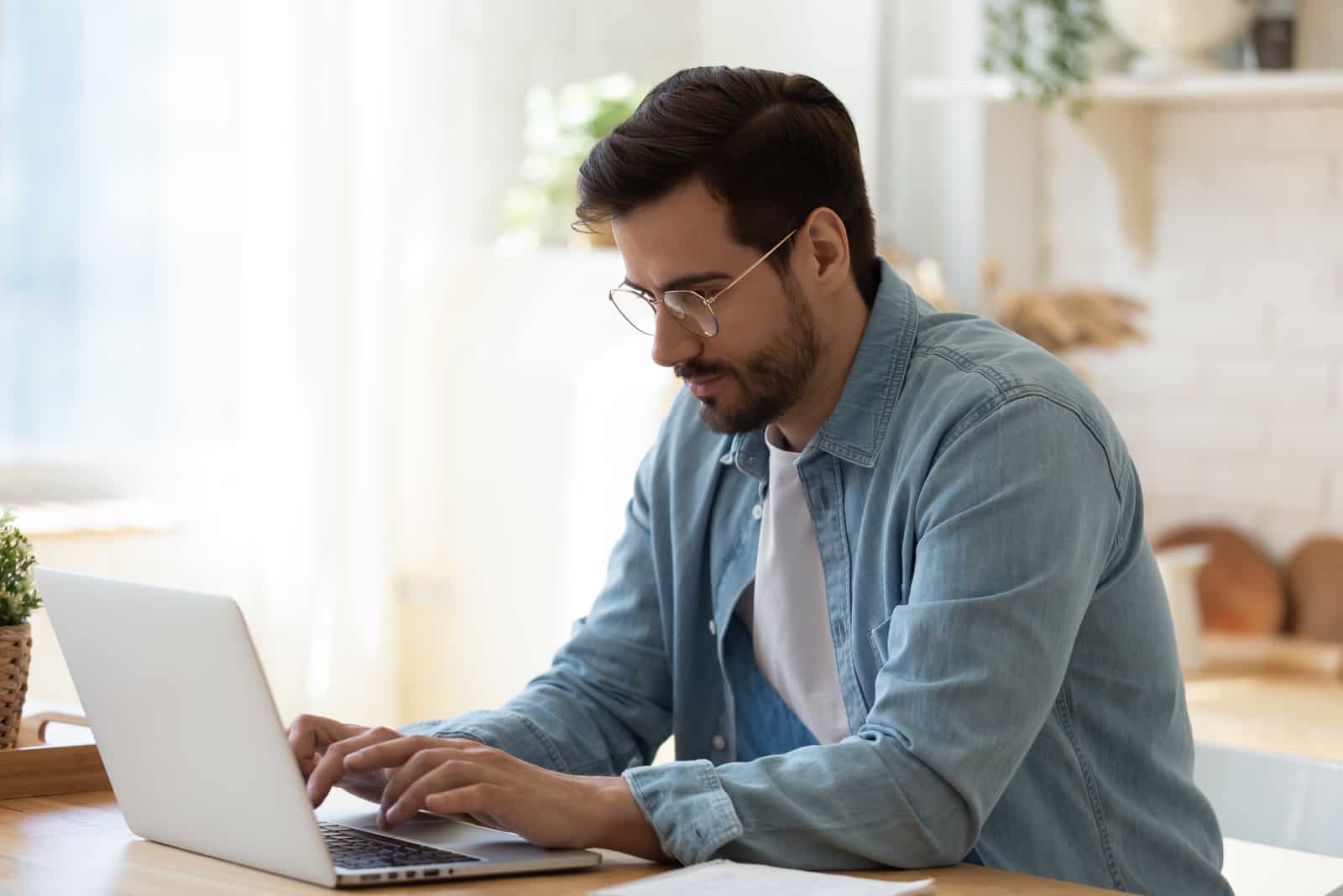 un homme est assis derrière un ordinateur portable et une clé