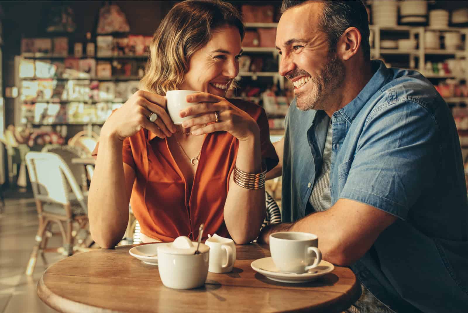 un homme et une femme buvant du café et riant
