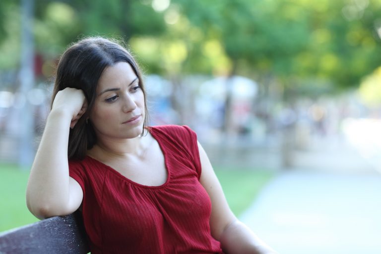femme réfléchie assis à l'extérieur