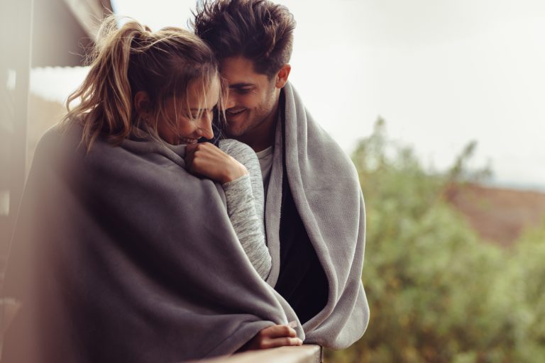 un couple se blottissant sous une couverture