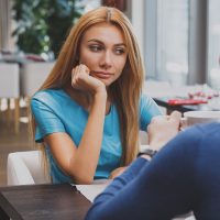 une femme pensive assise avec son petit ami dans le café