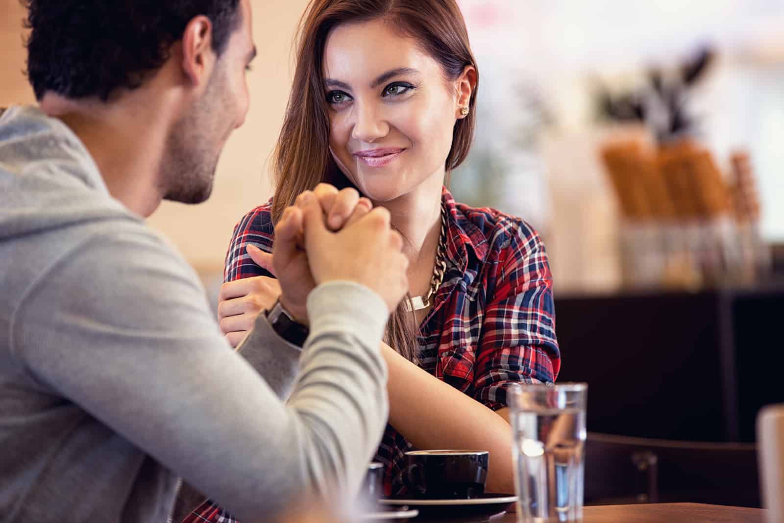Couple amoureux assis à table dans le café et se tenant la main
