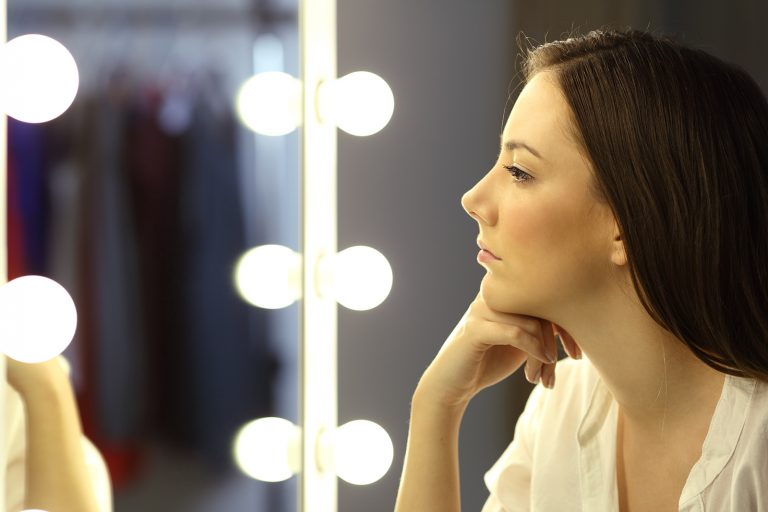 Une femme sérieuse confiante se regardant dans le miroir