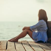 femme assise seule en regardant la mer