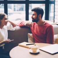 Femme et homme parlant lors de la première date dans un café confortable