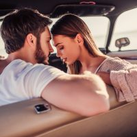 un homme et une femme sur le point de s'embrasser dans une voiture