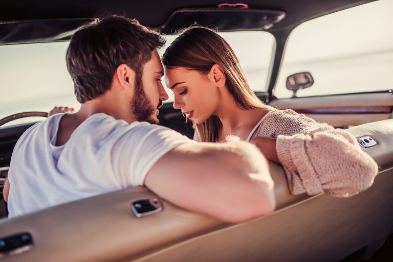 un homme et une femme sur le point de s'embrasser dans une voiture
