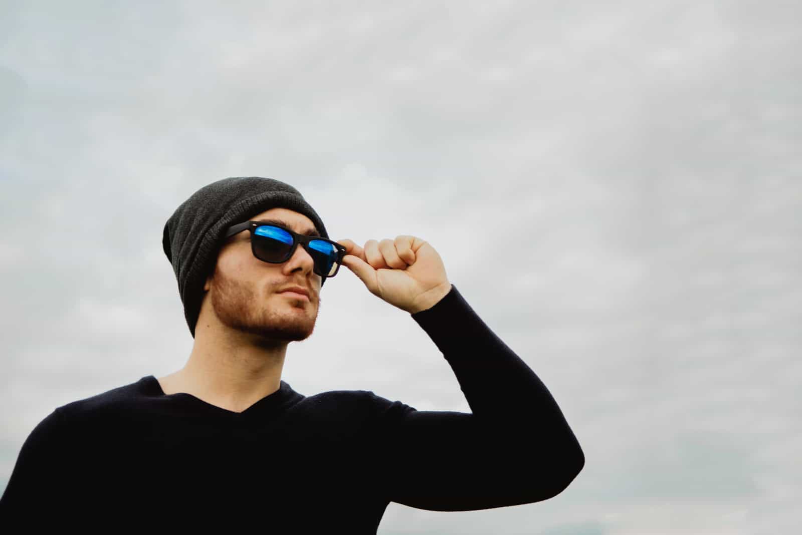 cool jeune homme à lunettes soleil et casquette