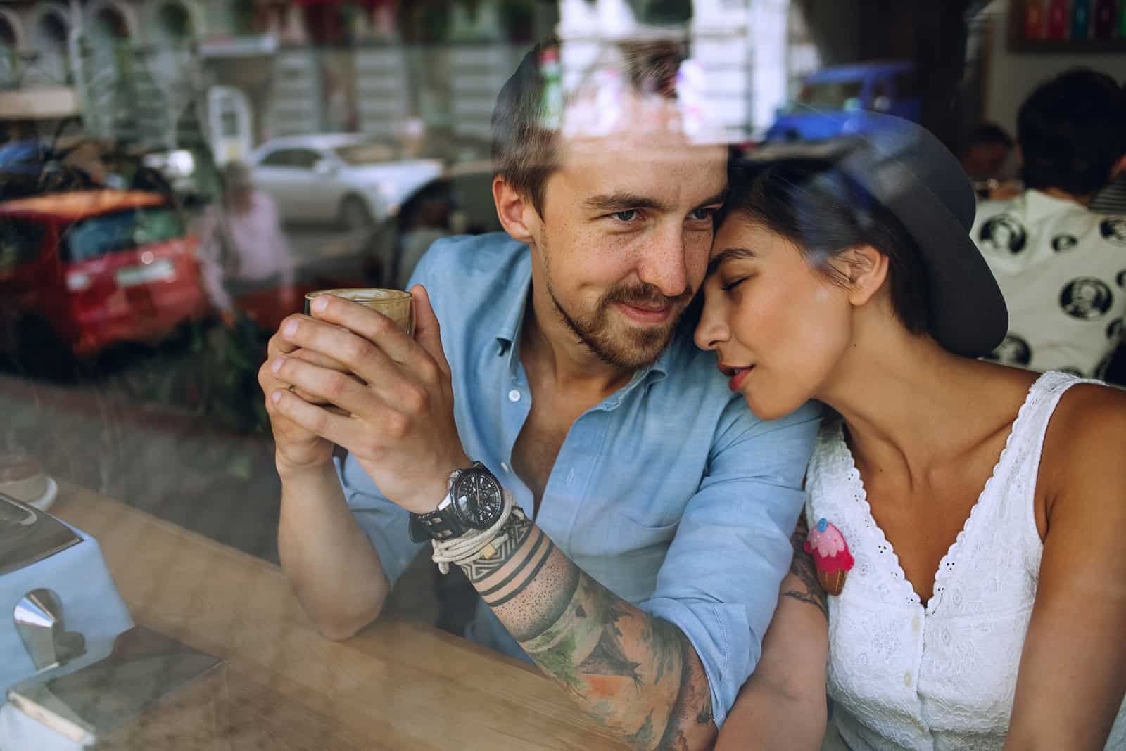 couple au repos dans un café derrière la fenêtre