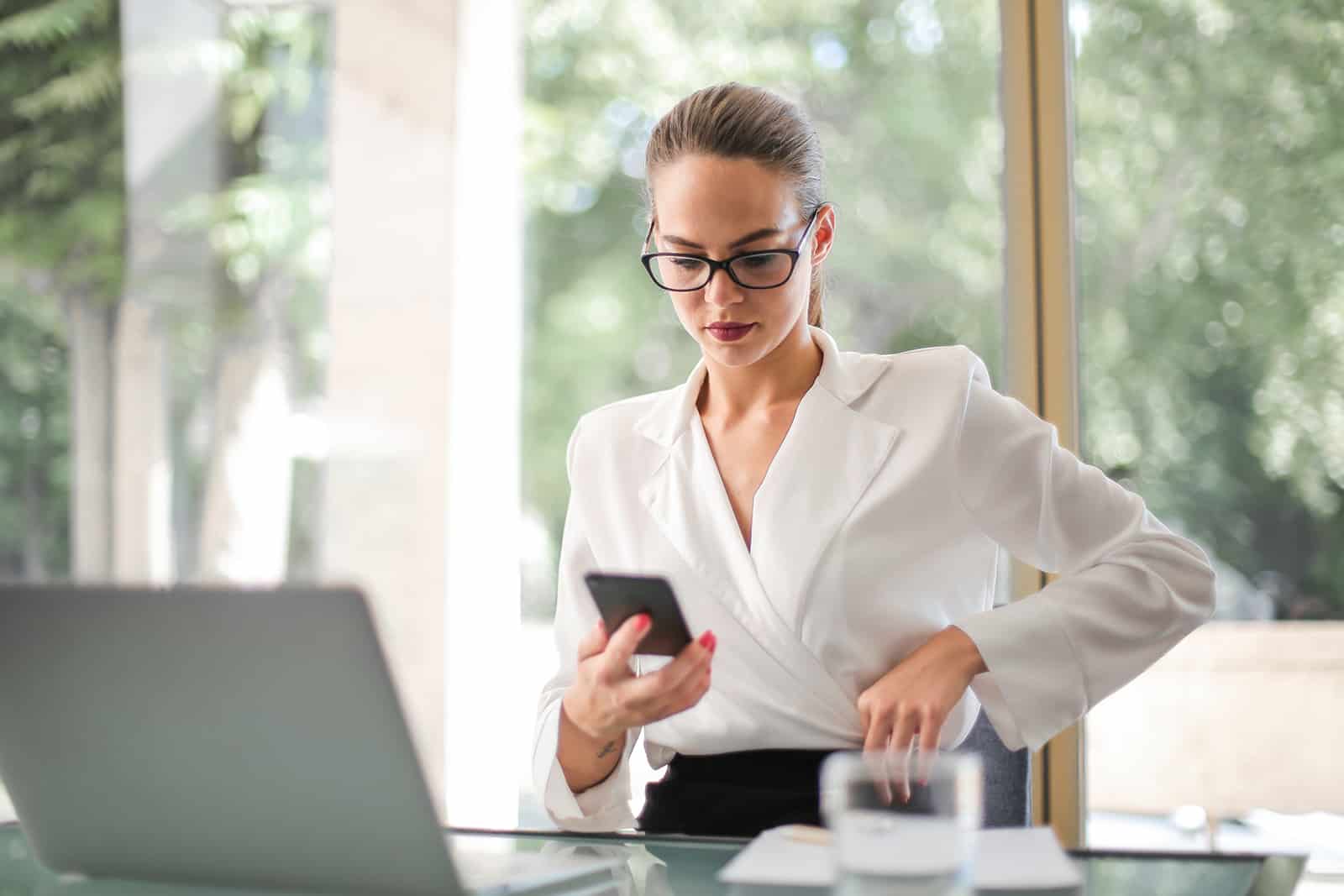 une femme d'affaires regardant smartphone dans le bureau