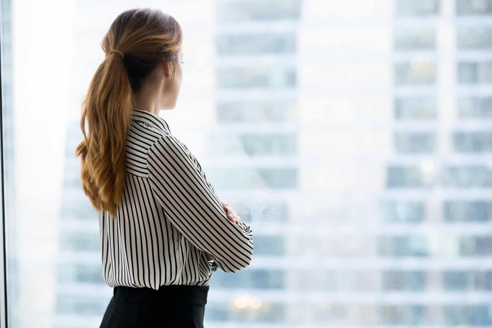 femme debout près de la fenêtre seule