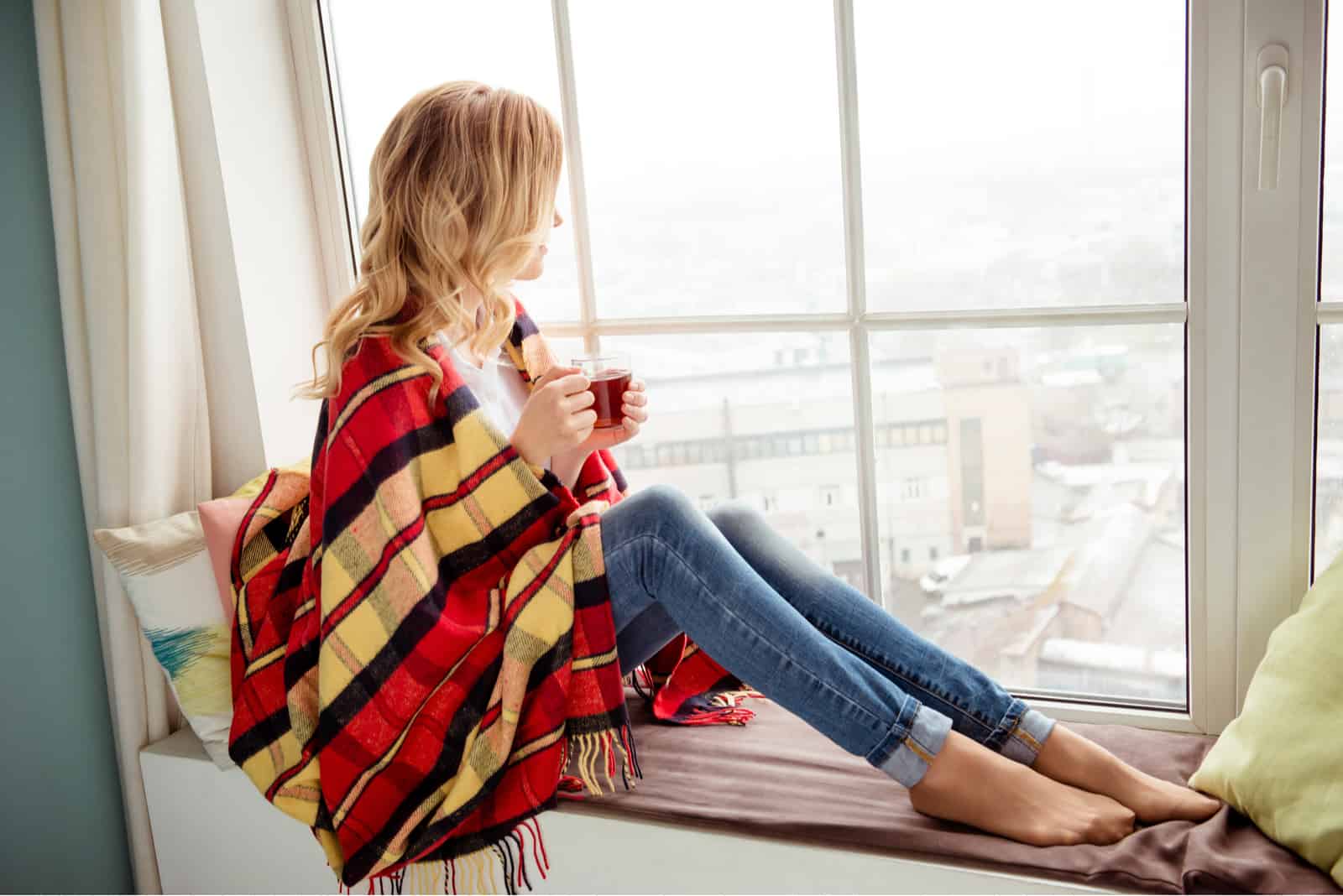 femme en plaid avec tasse de thé chaud