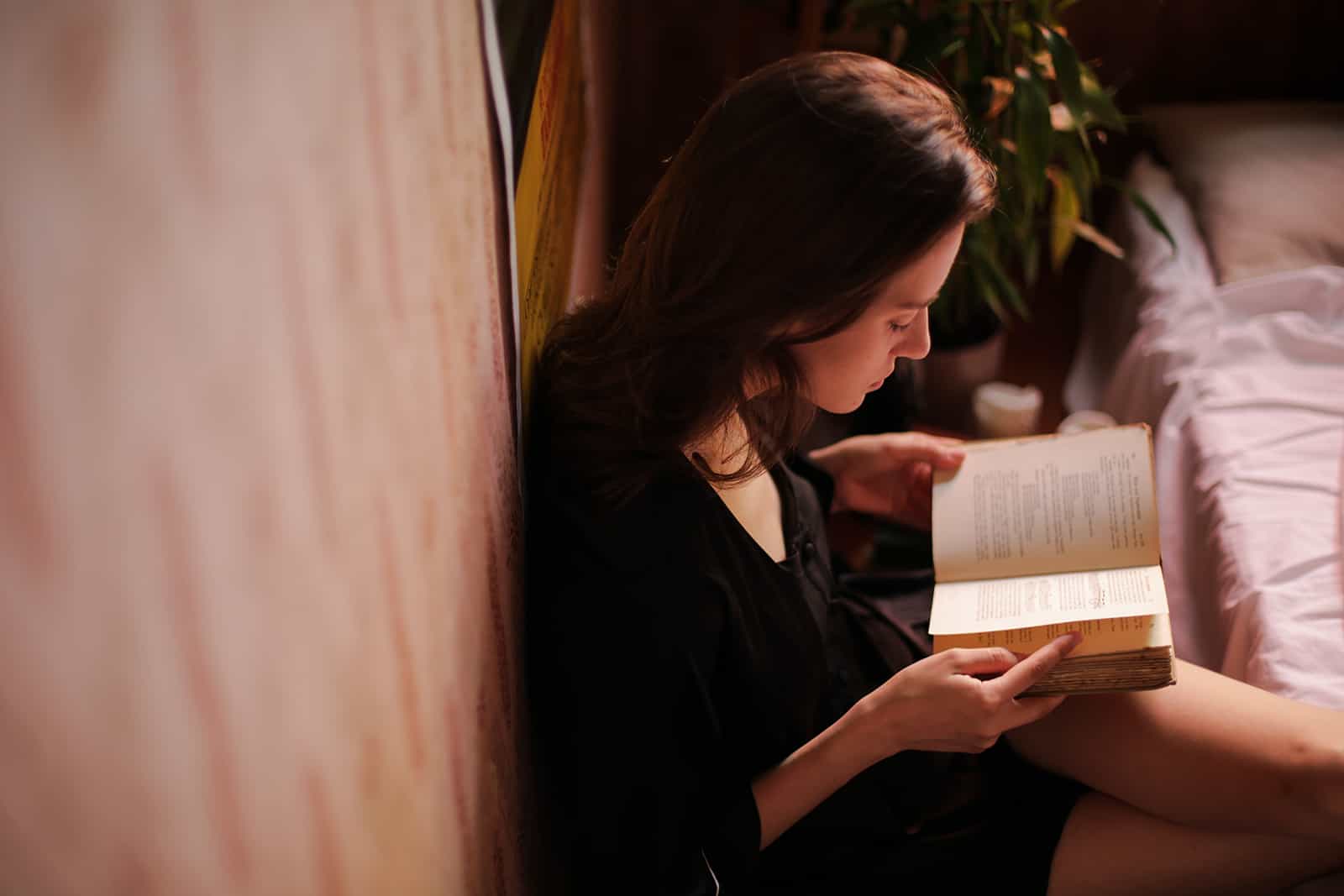 une femme lisant un livre dans une chambre