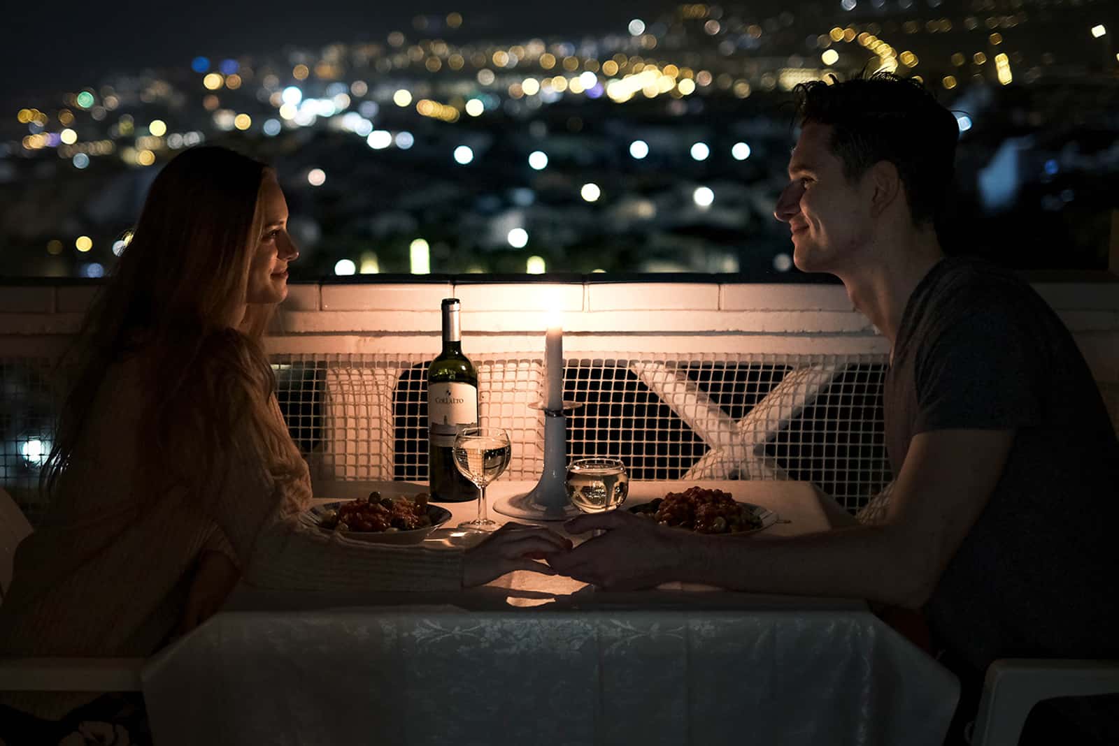 un couple amoureux dînant sur la terrasse main dans la main