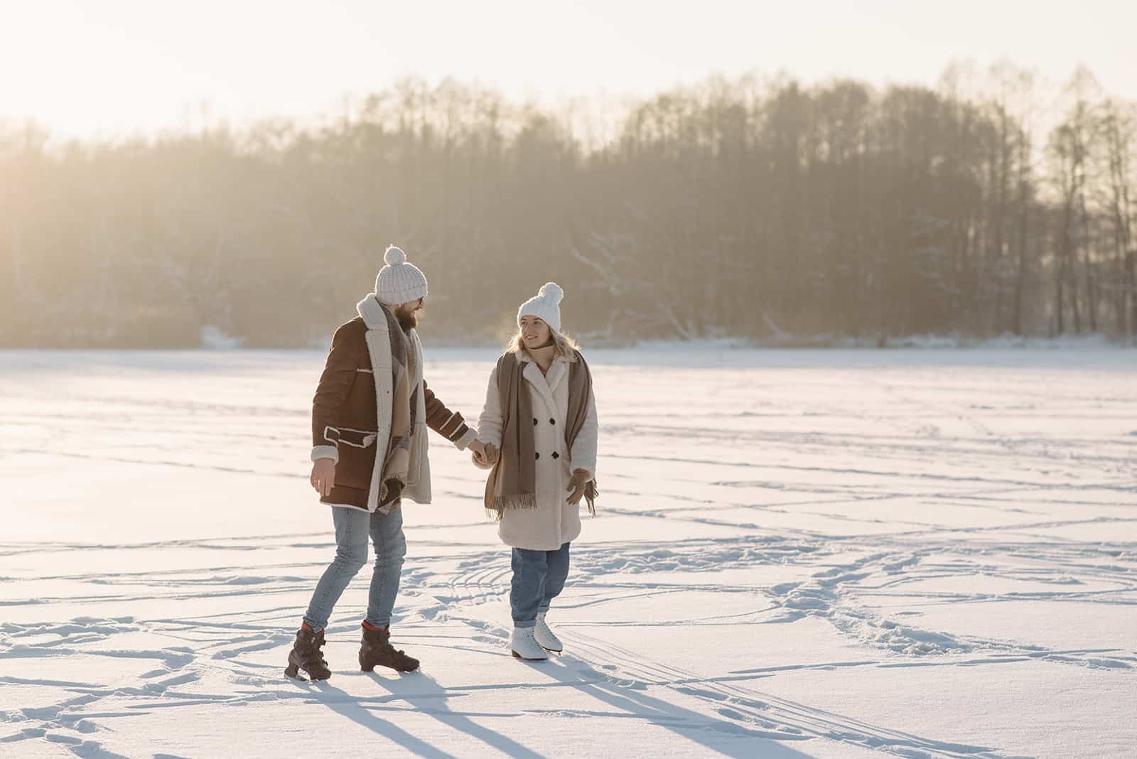 un couple amoureux patinage sur glace et main dans la main
