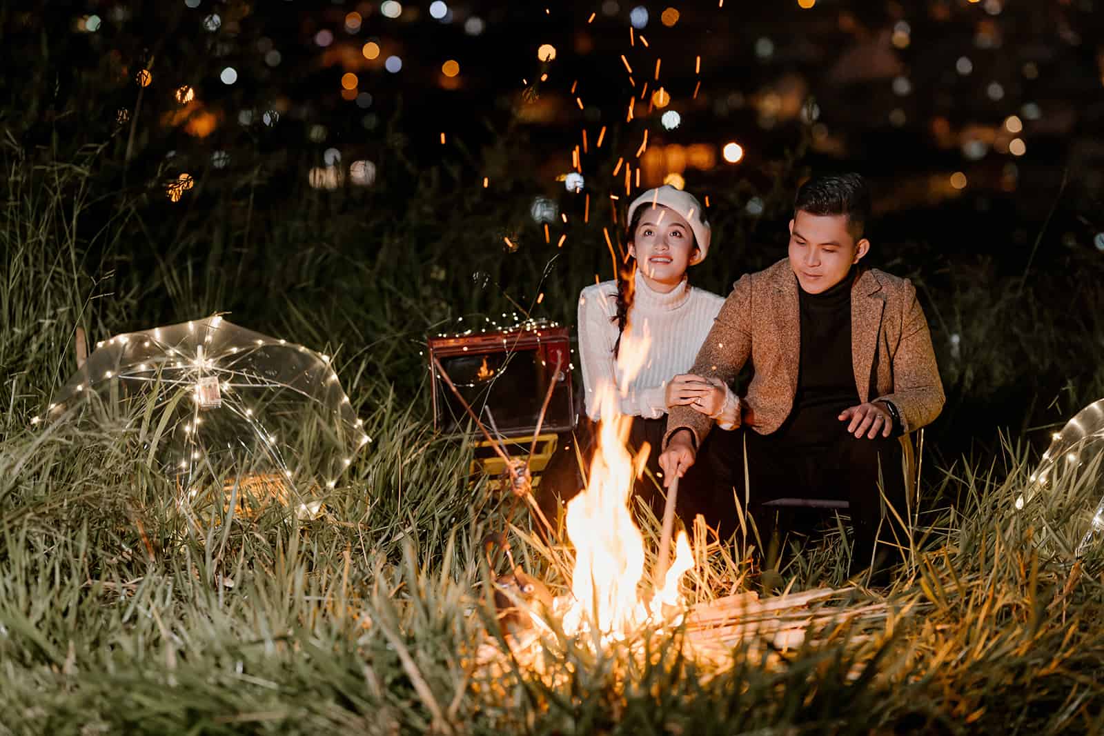 un couple assis près du feu la nuit