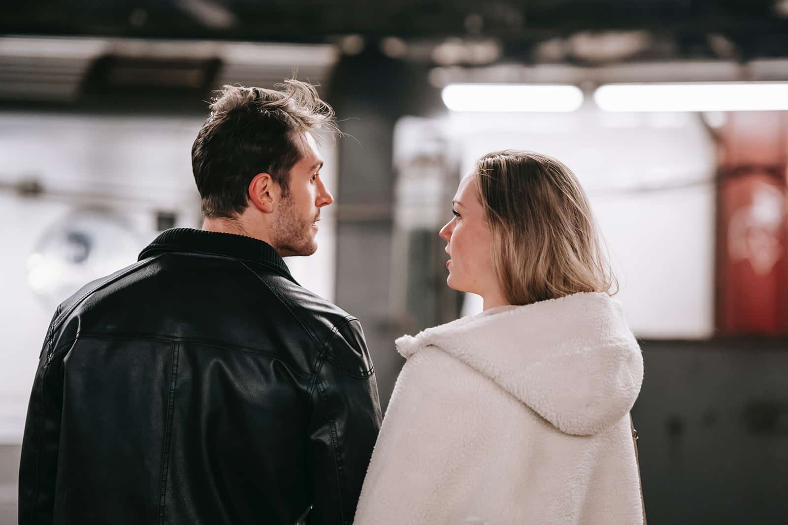 un couple debout dans un métro et se regardant