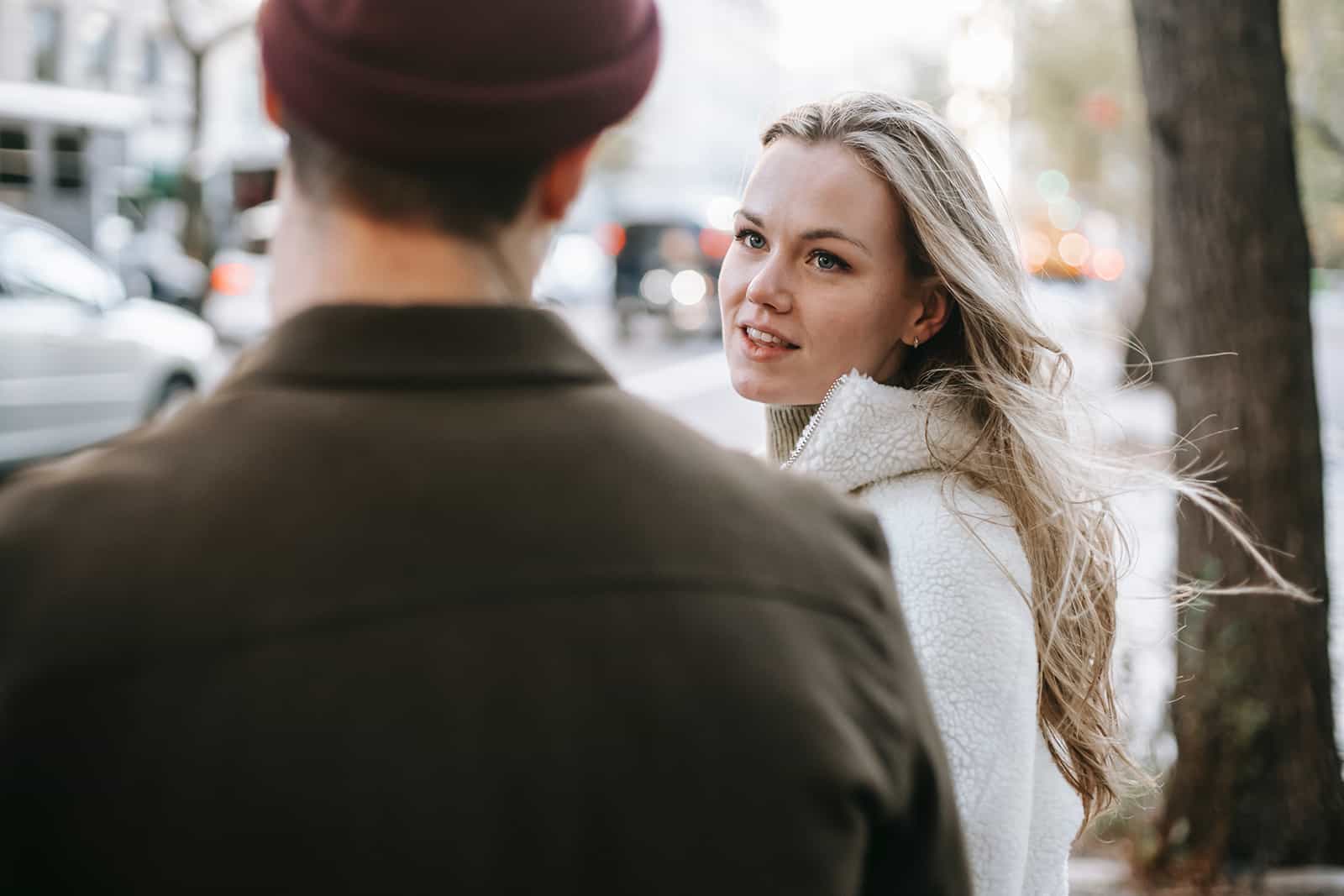 une femme blonde parle avec un homme dans la rue
