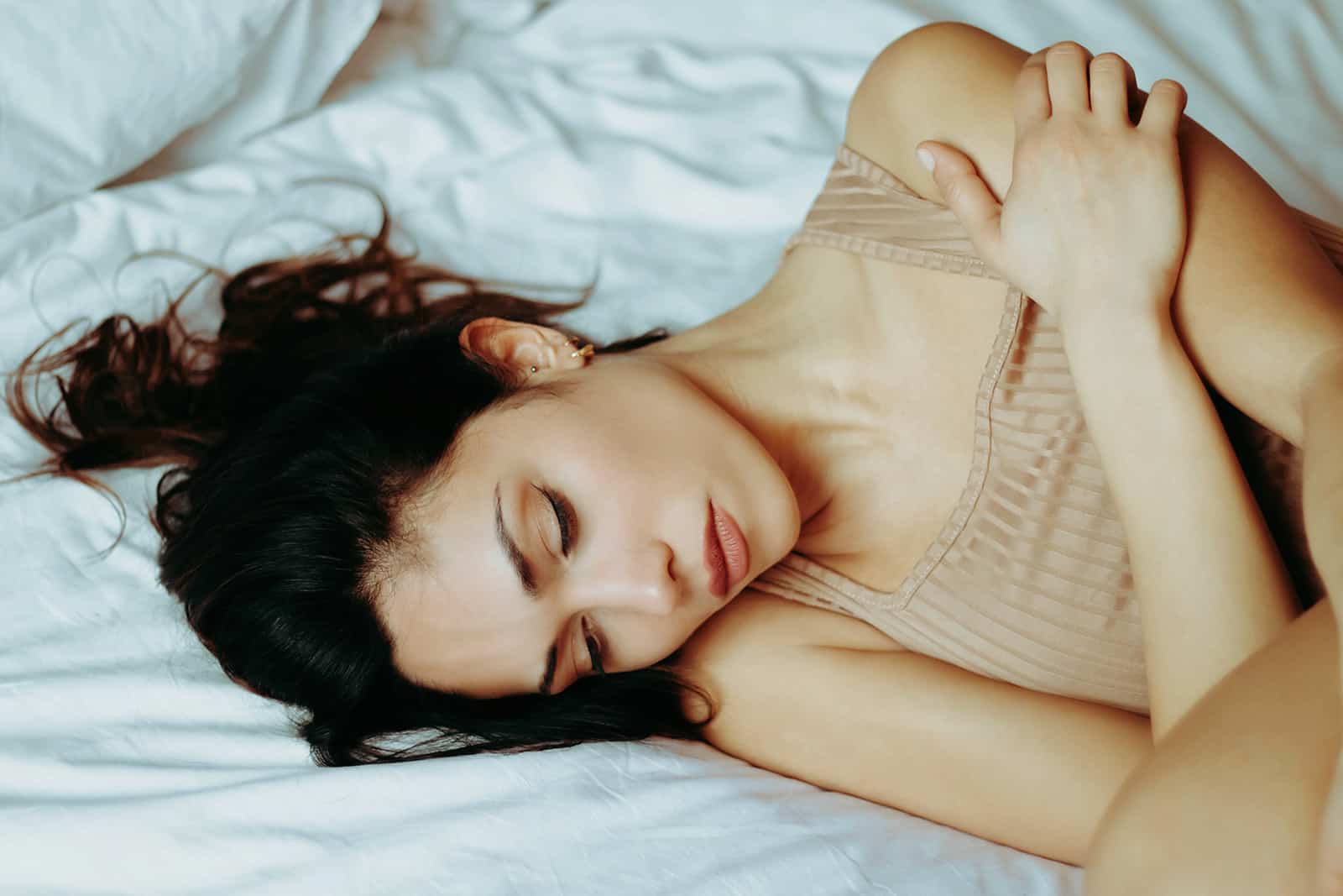 une femme triste allongée sur le lit et ressentant de l'anxiété