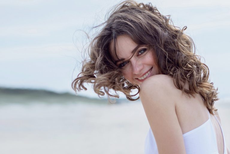 une belle jeune femme aux cheveux bruns avec un sourire sur son visage