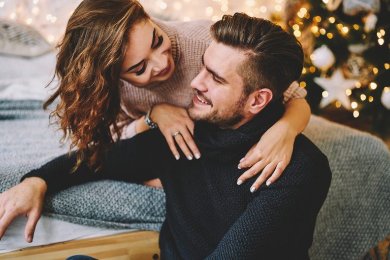 une jeune femme souriante étreint l'homme