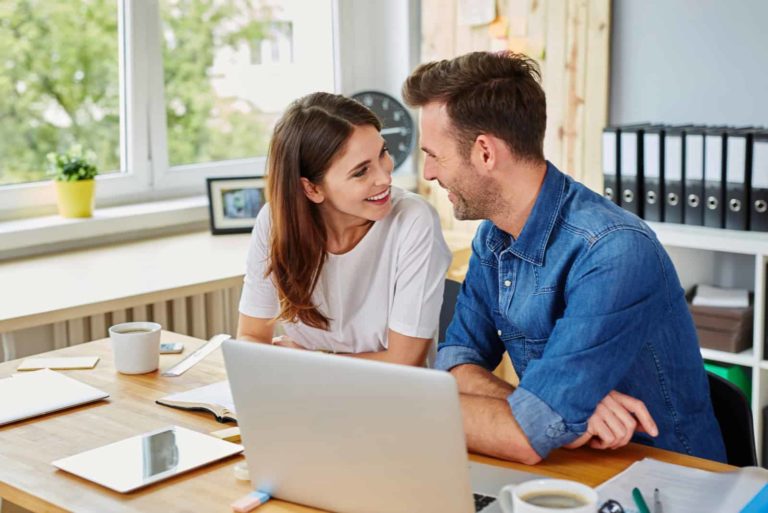 Heureux homme et femme travaillant ensemble au bureau en se regardant