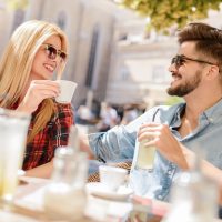 un homme et une femme assis buvant du café et souriant