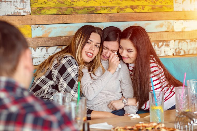 Amis réconfortant et consolant pleurer jeune femme essayant de la faire rire