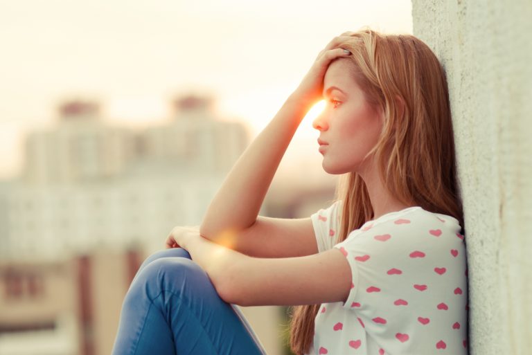une femme déçue s'assoit et regarde au loin