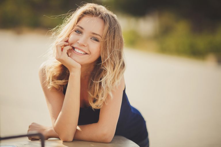 une belle femme aux longs cheveux blonds rit